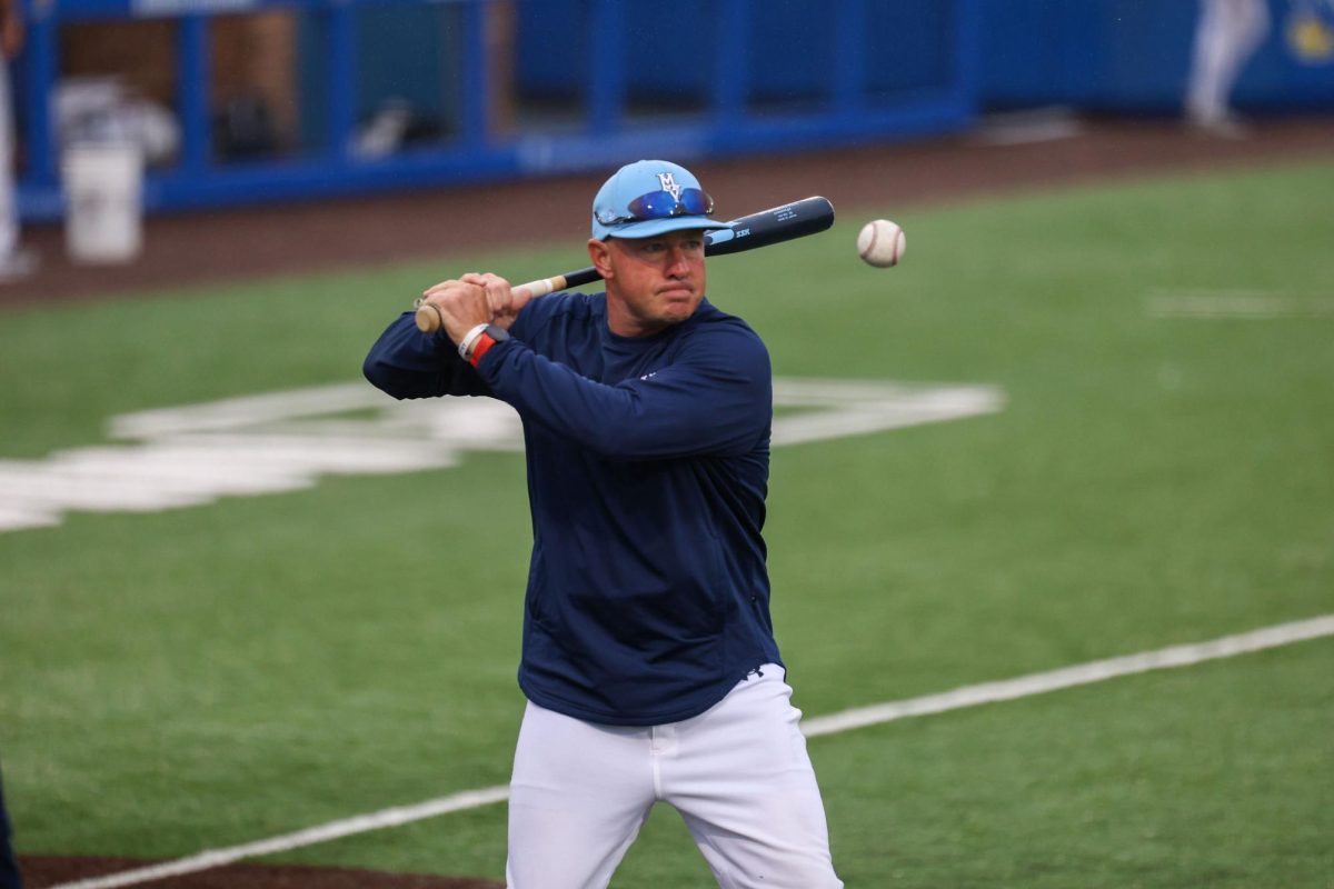 Eyes on the ball, coach Larry Benson hits to the outfielders during warmups