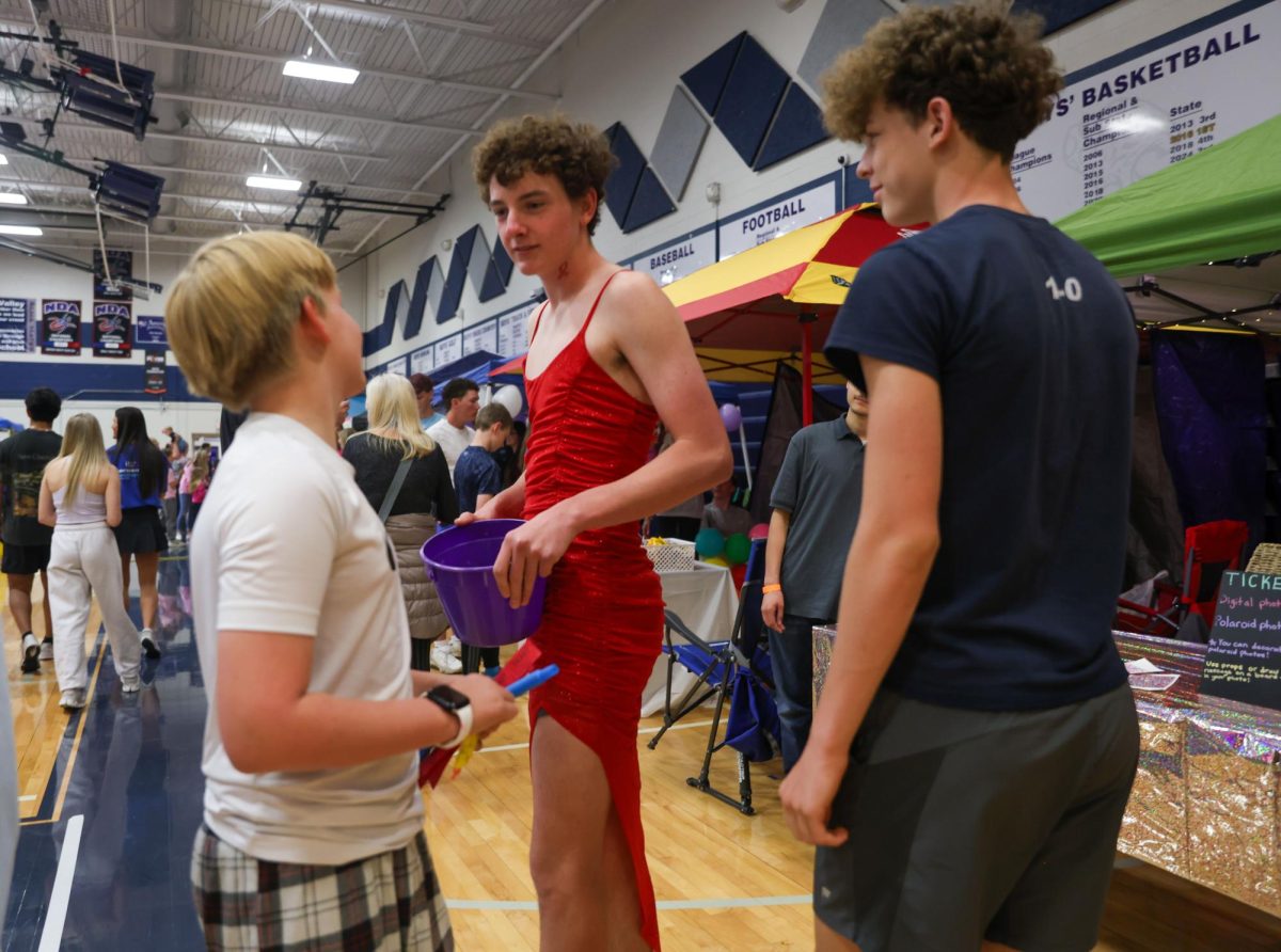 Mr. Relay Contestant, junior Blayne Vincent, asks a relay attendee for ticket donations.