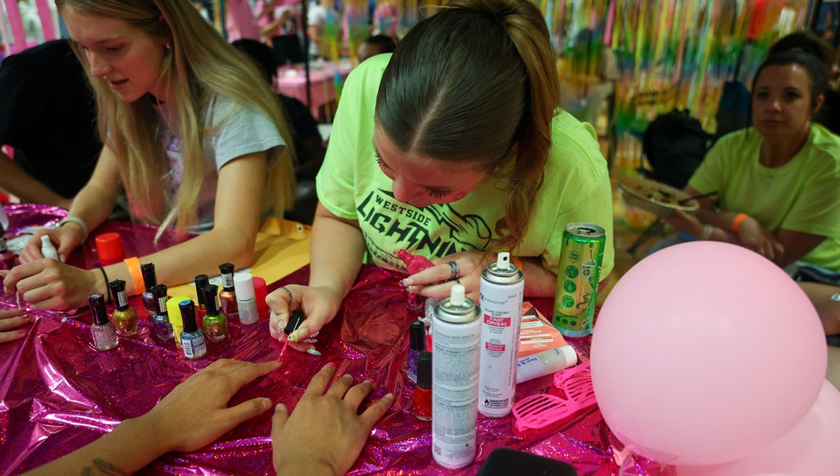 Senior Ava Mendez paints nails at her teams booth at the event.