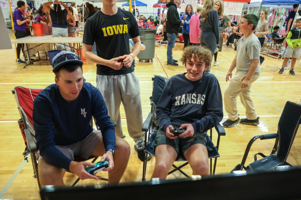 Teacher Kurt Golubski and Junior Evan Hayes play NBA2K at a booth.
