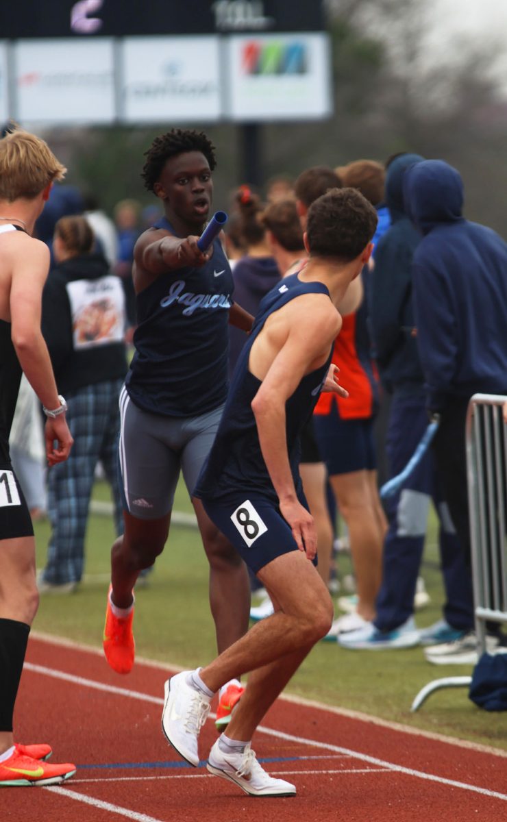 Arm outreached, sophomore Gabe Mattai hands the baton to his teammate.