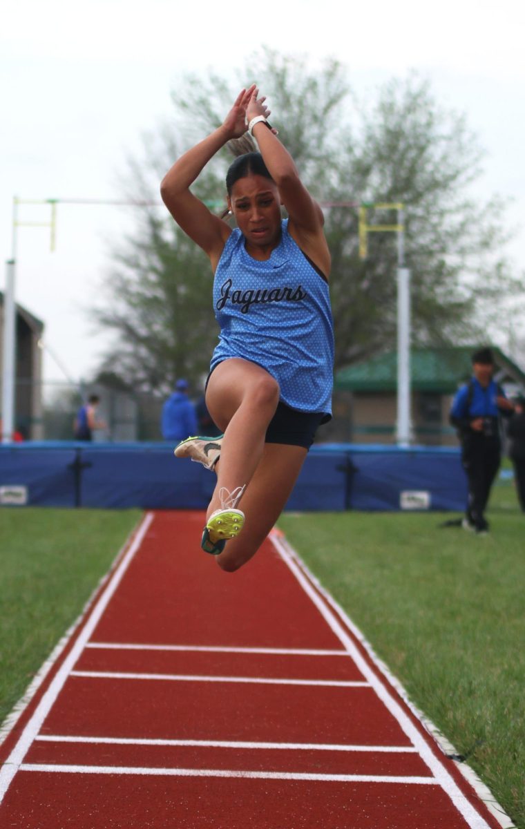 Arms up, senior Kaidence Alston jumps towards the sand.