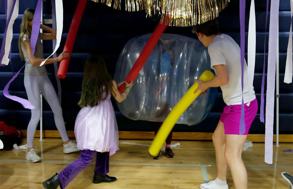 Kids from the community are playing in a booth where the goal is to hit the person in the inflated ball, Saturday, March 28.