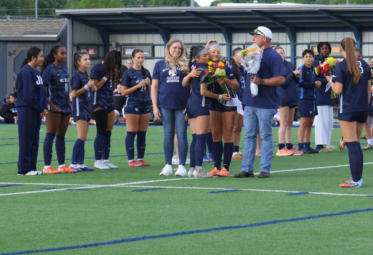 Senior Emma Carbajo is honored with flowers and a hug from junior Olivia Meneses. 