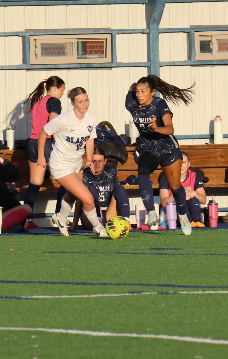 With determination, junior Gracie Garcia dribbles down the field to try and get a shot on the goal.