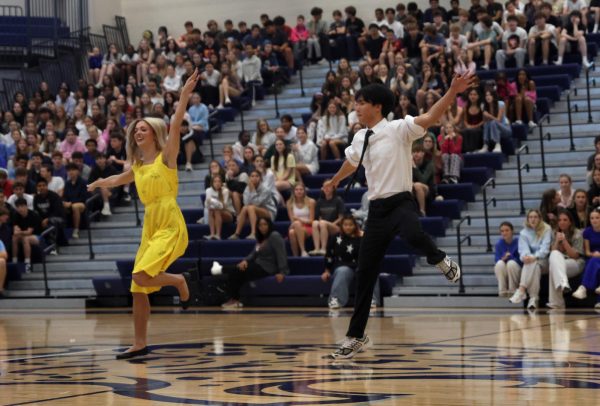 Leaping in the air, seniors Brooke Seymour and Noah Kim dance to a song from “La La Land” at the pep assembly, Thursday April, 16.