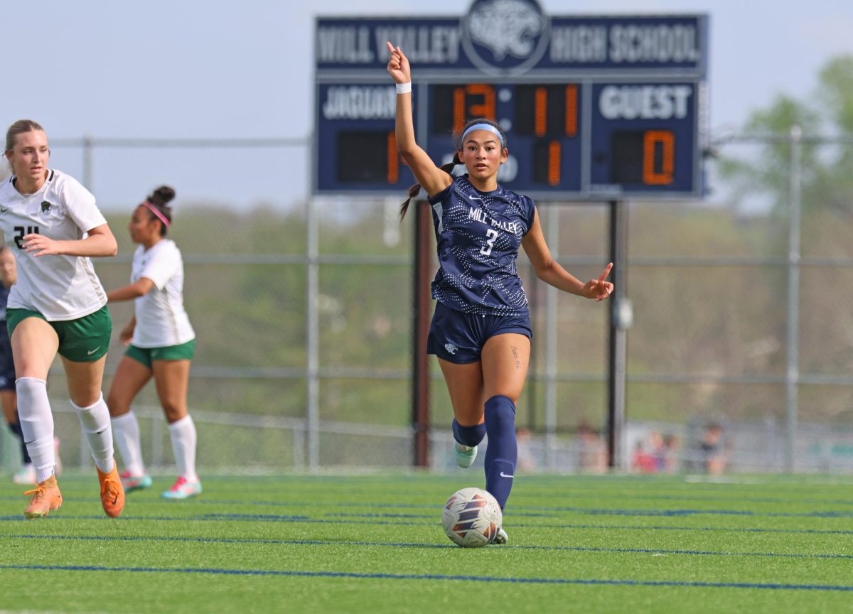 Pointing up the field, junior Grace Garcia prepares to pass the ball to her teammate.