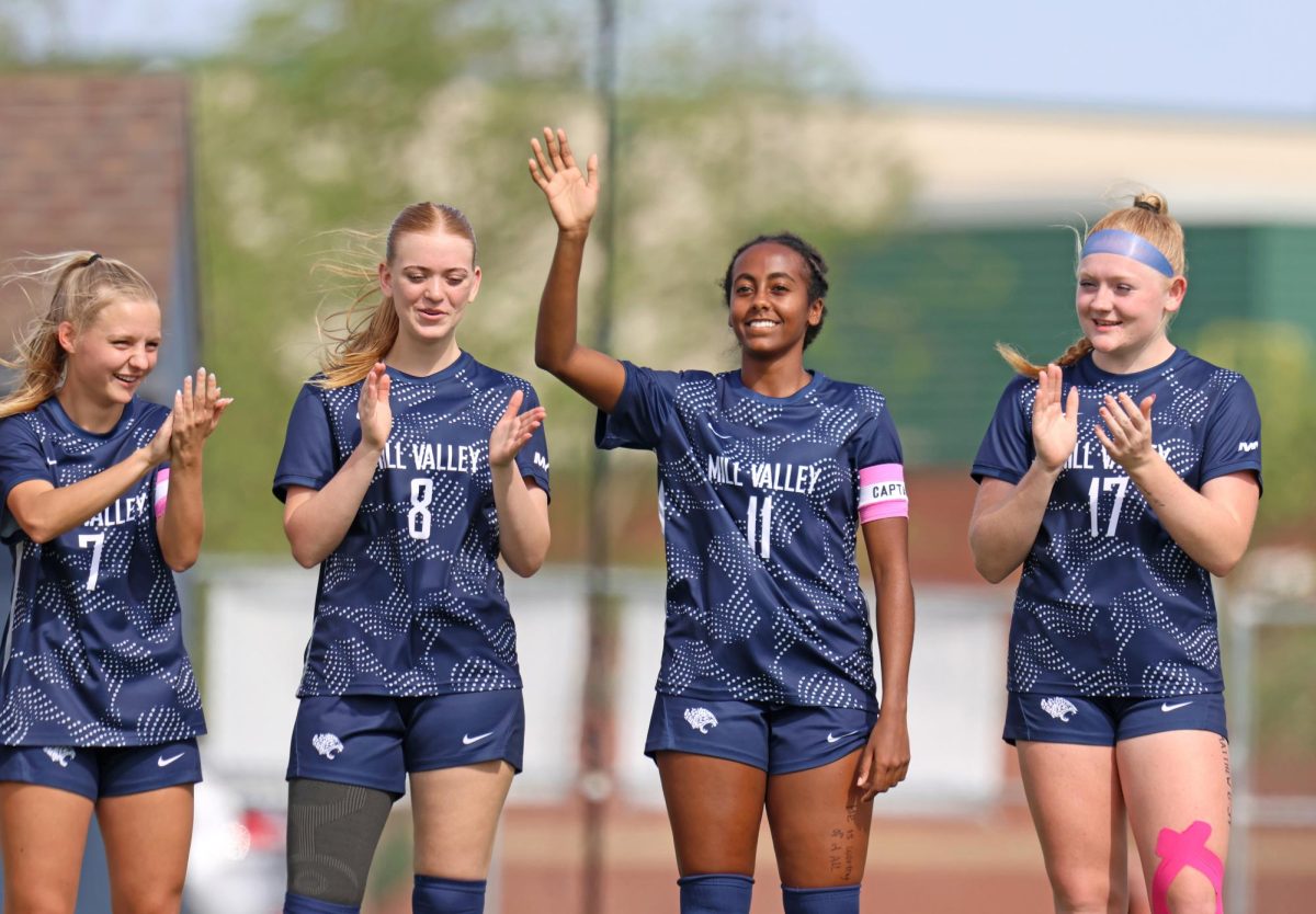 In the starting lineup, junior Biti Hasabu waves as the announcer calls her name.