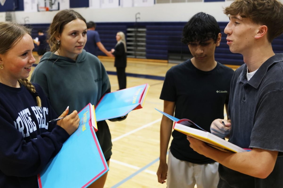 Reminiscing the year, sophomores Annika Vaught, Paige Inghram, Yuriel Garcia and Noah Lauer share stories while exchanging yearbooks.