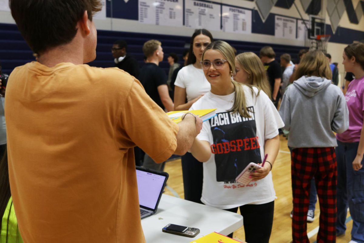 With a smile on her face, sophomore Brooklyn Roush thanks junior August Reeves for receiving her yearbook. 