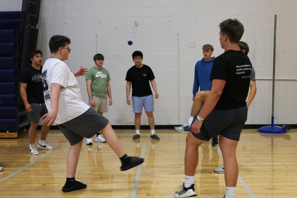 Feet waiting in anticipation, a group of juniors plays hacky sack while waiting for the yearbook lines to shorten. 