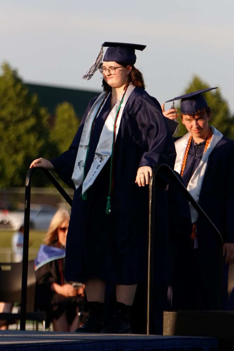 Hands on the railing, senior Evie Tindell waits for her name to be called.