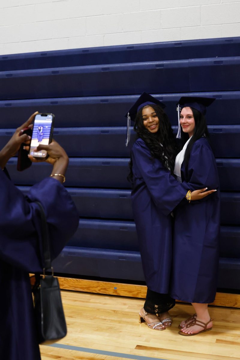 Posing for a photo, senior Lilly Gibson smiles with her friend before the ceremony.
