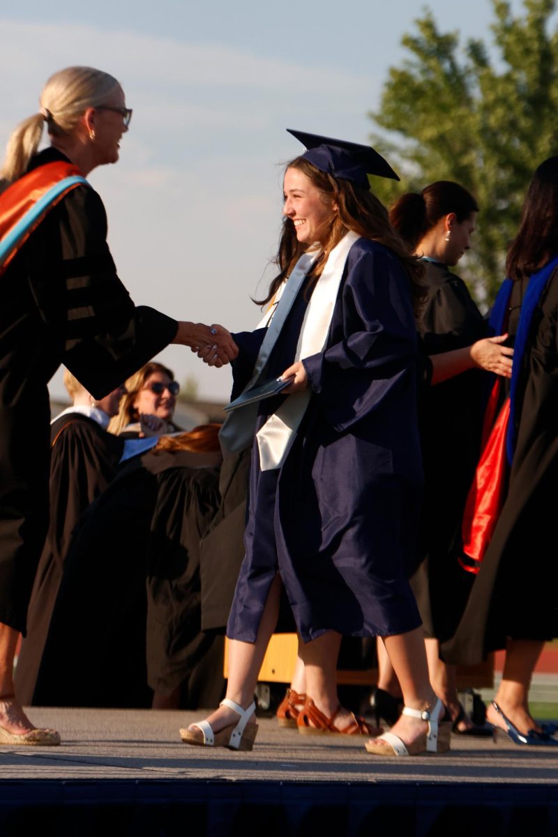 Walking across the stage, senior Stella Harryman retrieves her diploma.