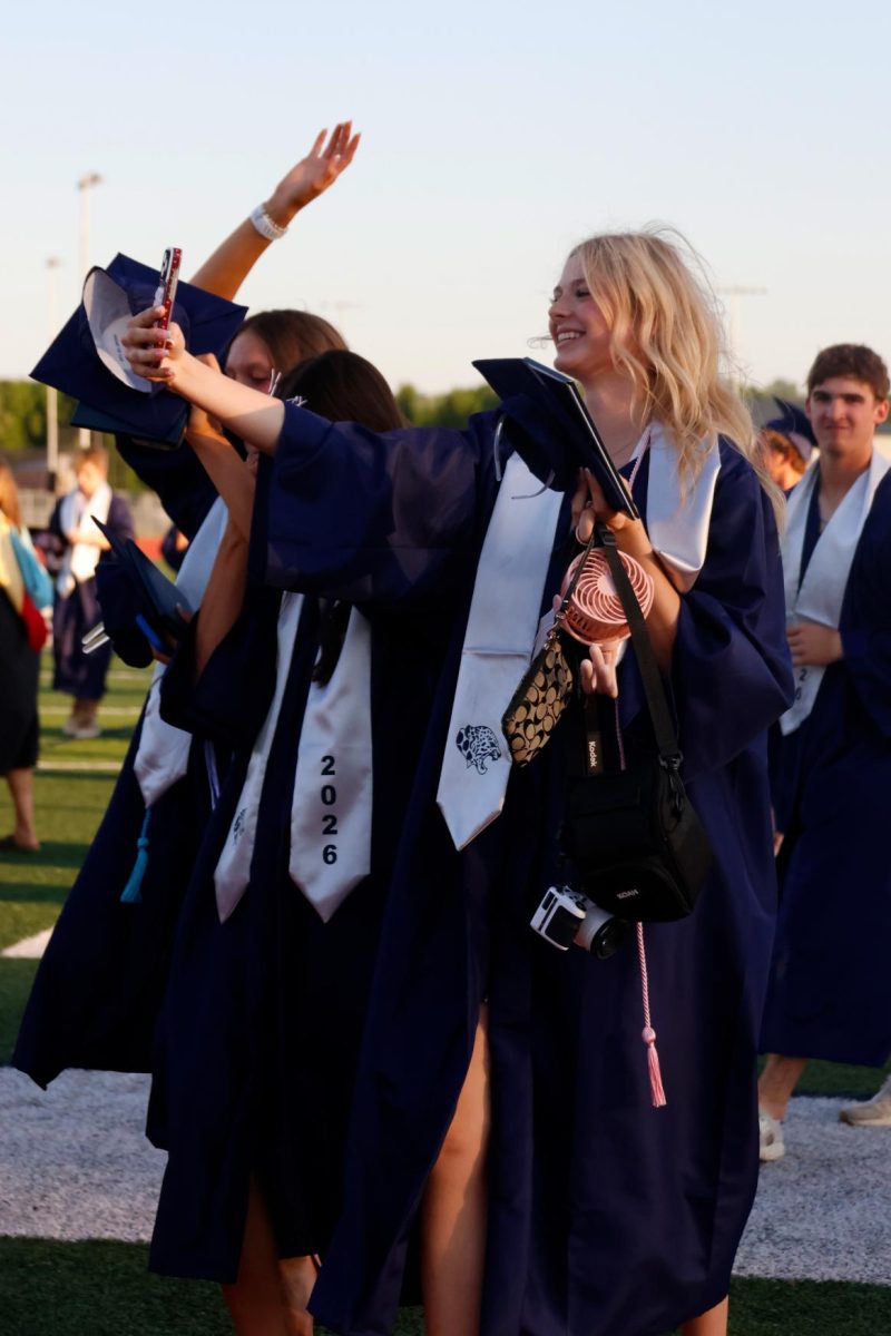 Arm up, Lila Cobb takes a selfie with her diploma after the graduation ceremony.