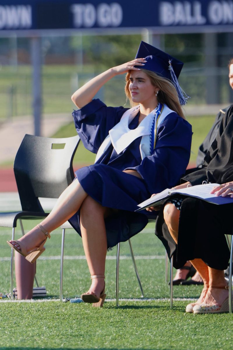 Touching her cap, senior Claire Cooper prepares to give her speech.