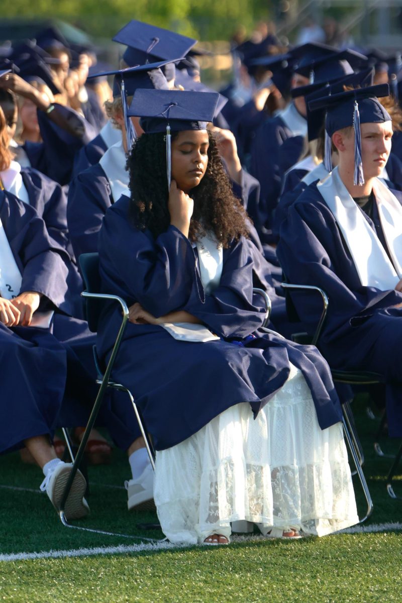 Holding her tassle, senior Abigail Abebe listens to the very final speech before seniors can flip their caps.