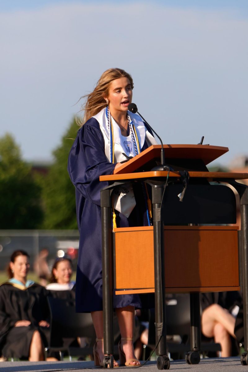 In front of the podium, senior Claire Cooper gives her student body president speech.
