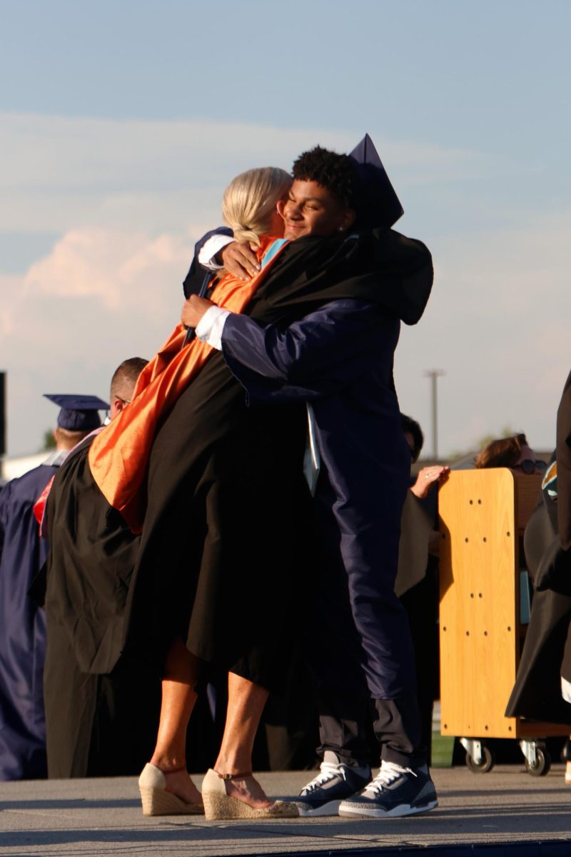 Hugging, senior Daniel Davis and principal Gail Holder say their goodbyes.