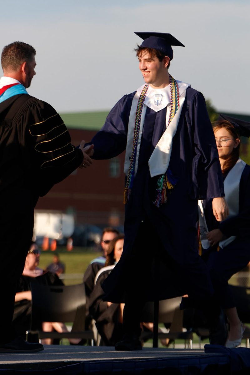 Shaking hands, senior Barron Fox and the superintendent collects his diploma.