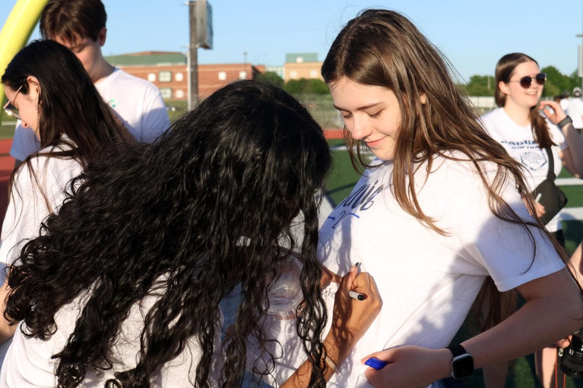Senior Rachel Joseph signs senior Madelyn Mulryan's shirt.