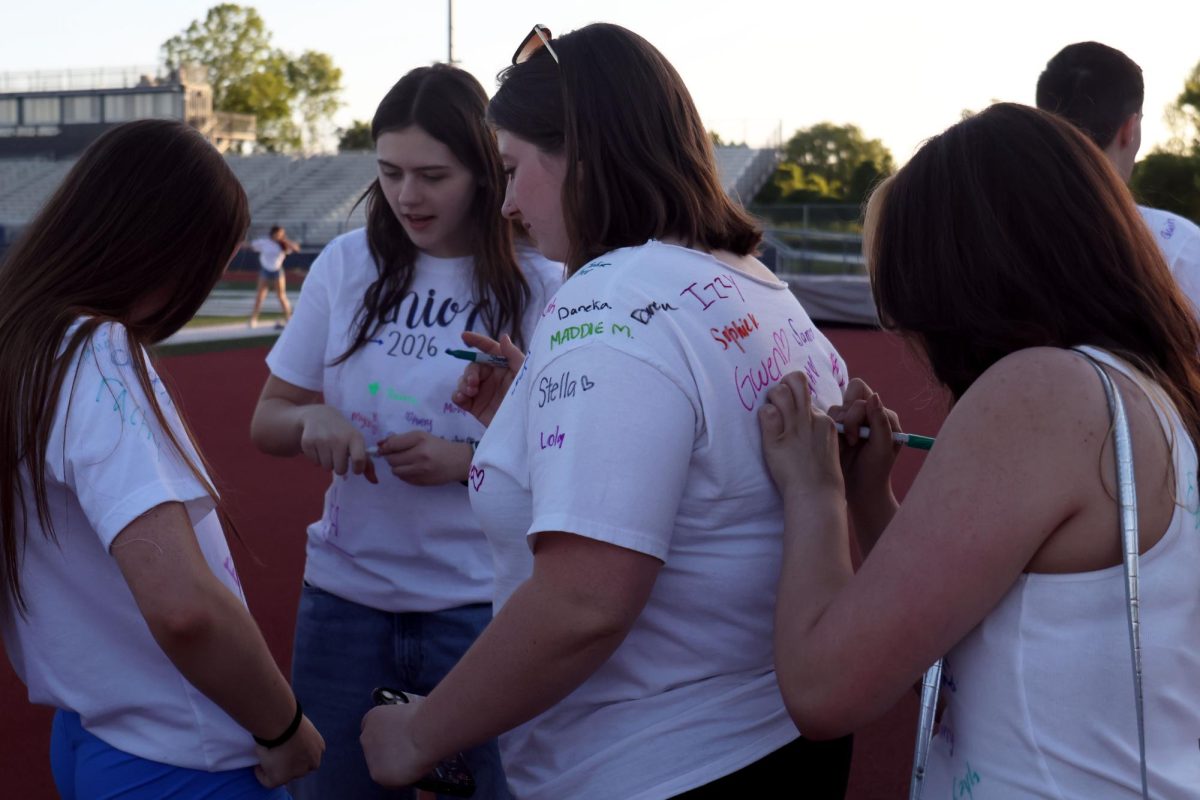 Seniors Mya Franco and Madelyn Mulrayn signs the shirts of seniors Aubrey Cliff and Liberty Bouskill.