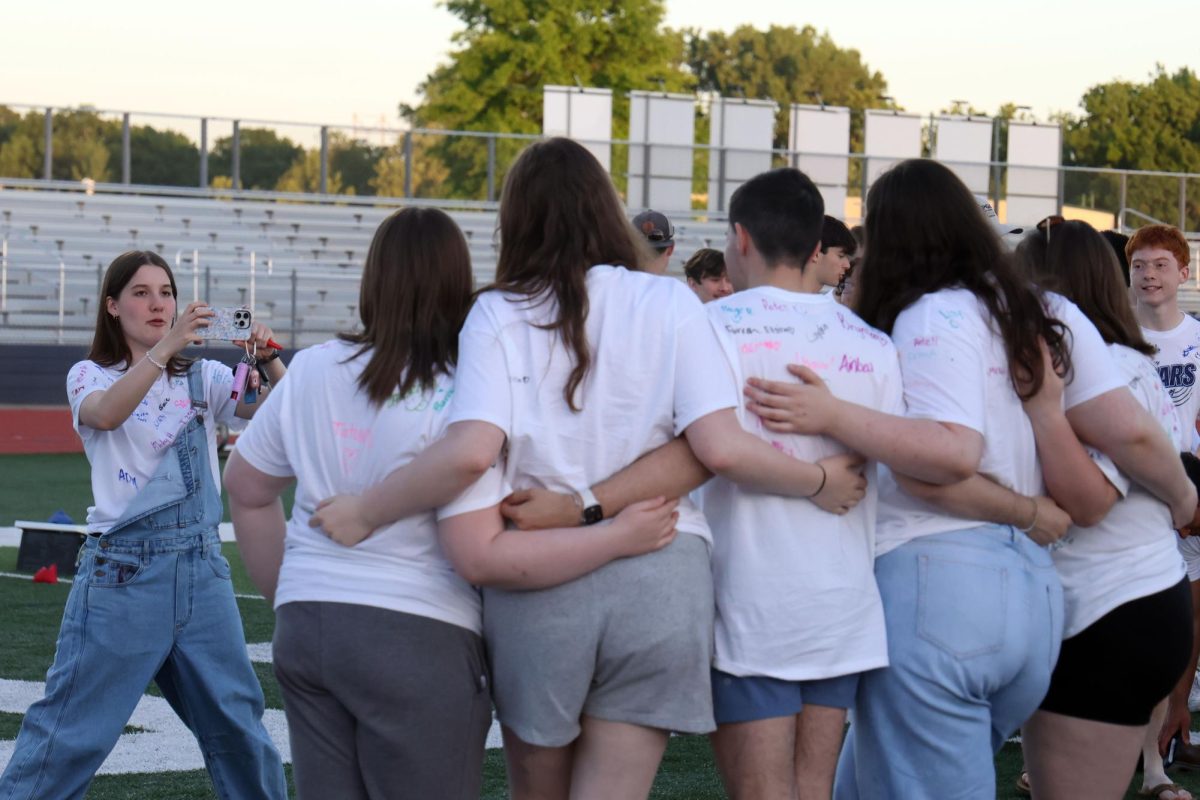 Phone in her hands, senior Hannah Stephensen takes a photo of seniors Izzy Simms, Josey Crossley, Steven Butler, Samantha McCoy and Liberty Bouskill.
