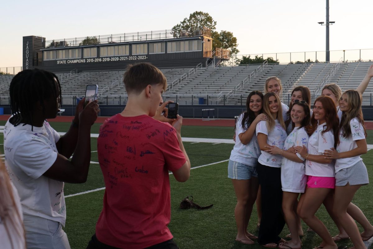 Seniors Cayden Rotich and Grant Kuchynka work together to capture photos of a senior friend group. 